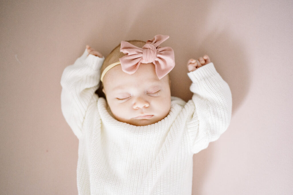 baby girl sleeping with hands up during newborn session