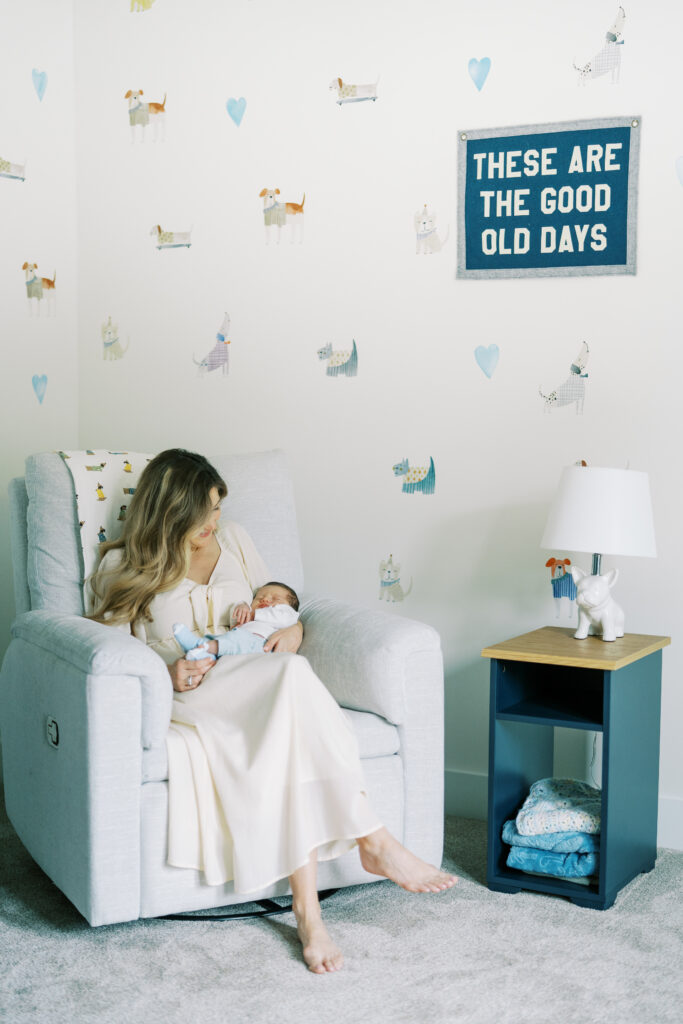 mother sitting in rocking chair holding newborn baby in nursery