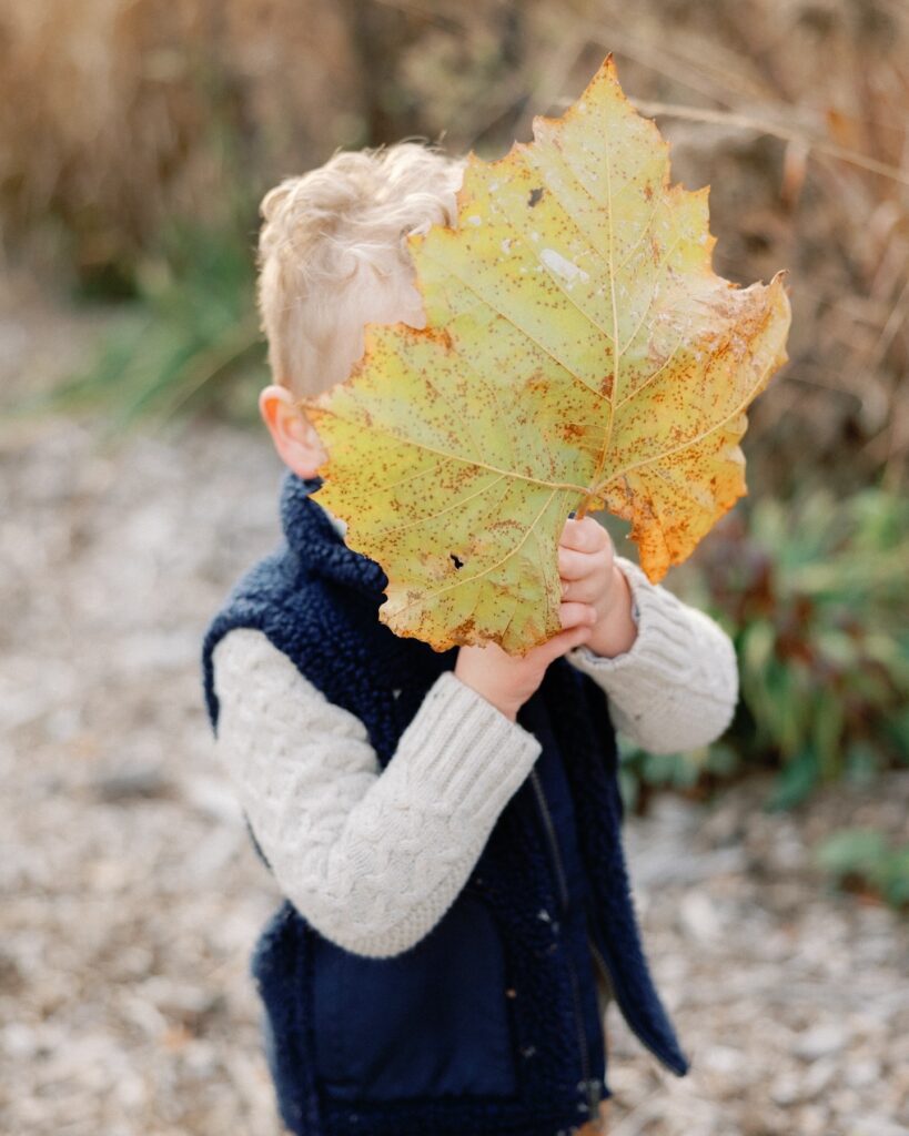 baby with leaf in his face at Indianapolis pumpkin patch