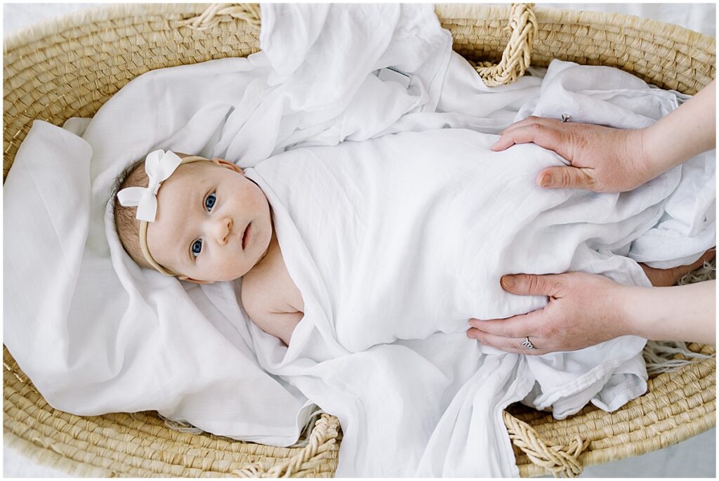 baby looking up from basket during studio newborn photography session