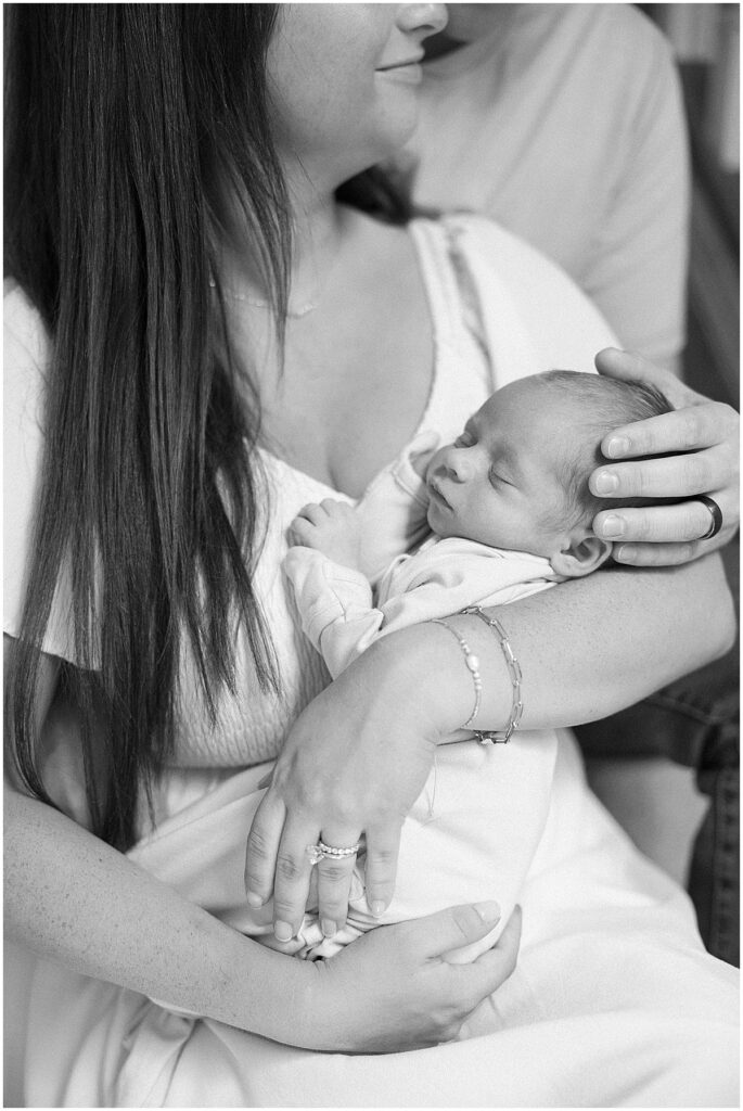 newborn baby sleeping in mother’s arms