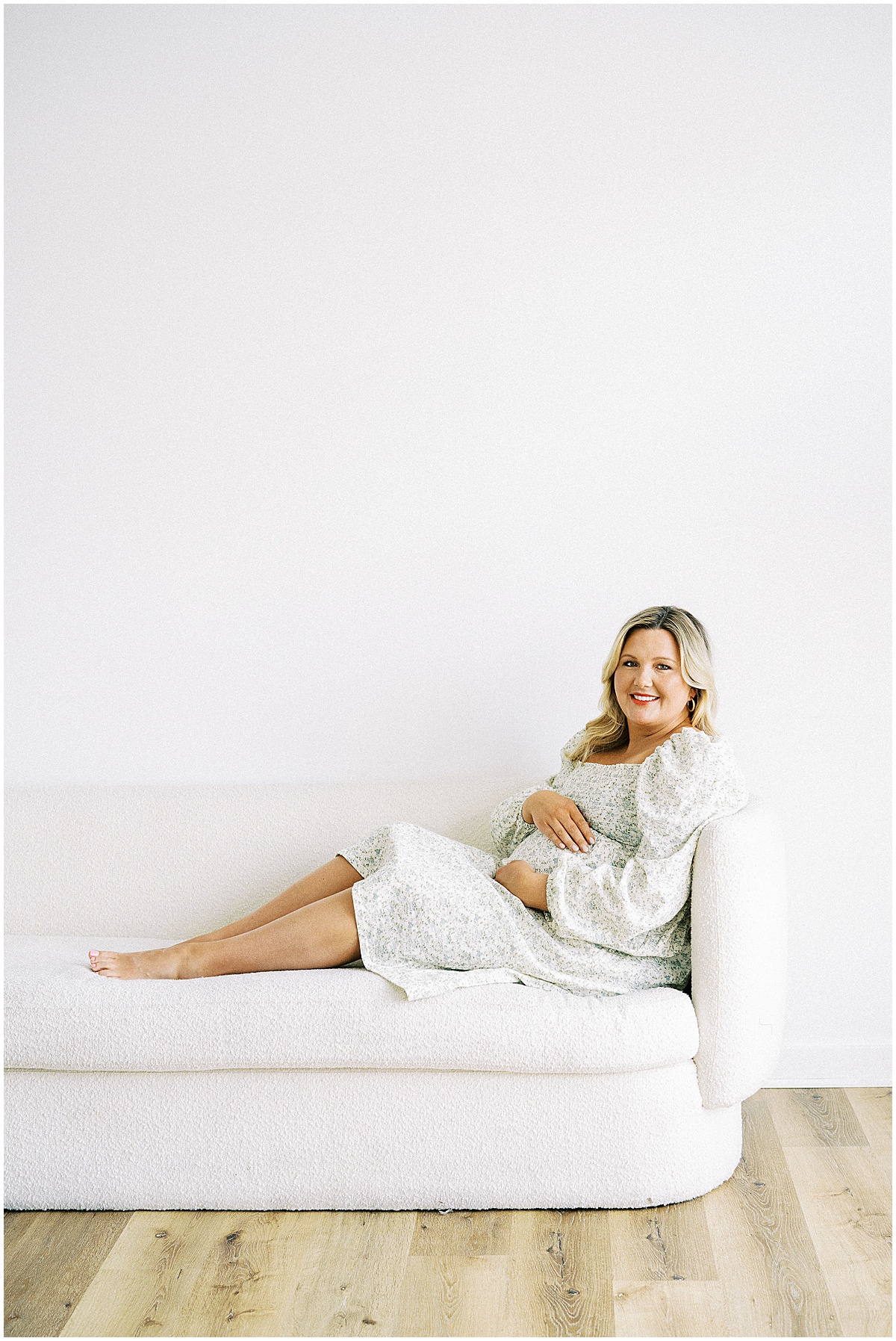 pregnant woman sitting on couch smiling