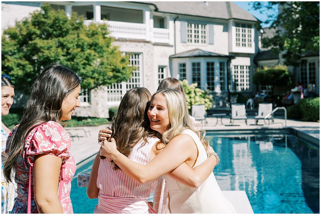 Event photography of guests hugging at summer baby shower