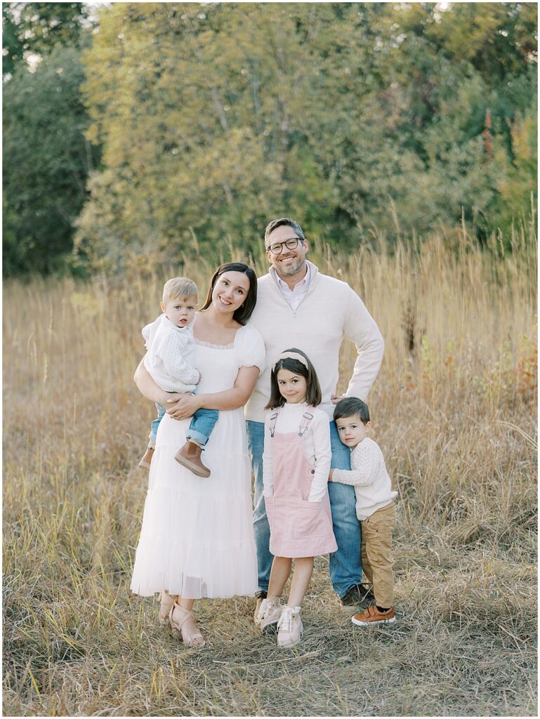 Family with three children get close for fall family photos in Central Park