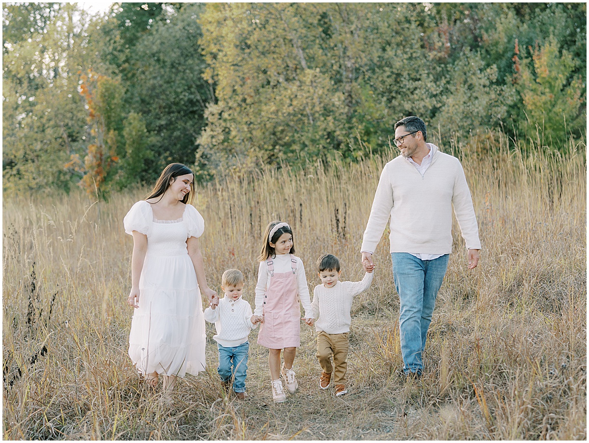 Family of 5 walk hand in hand during outdoor fall session