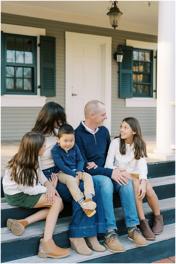 Family sits on steps during classic fall family photos in Indianapolis
