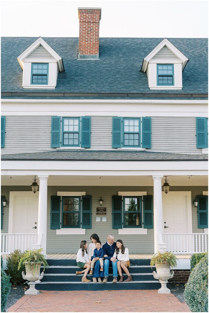 Family sits on steps during fall family photos