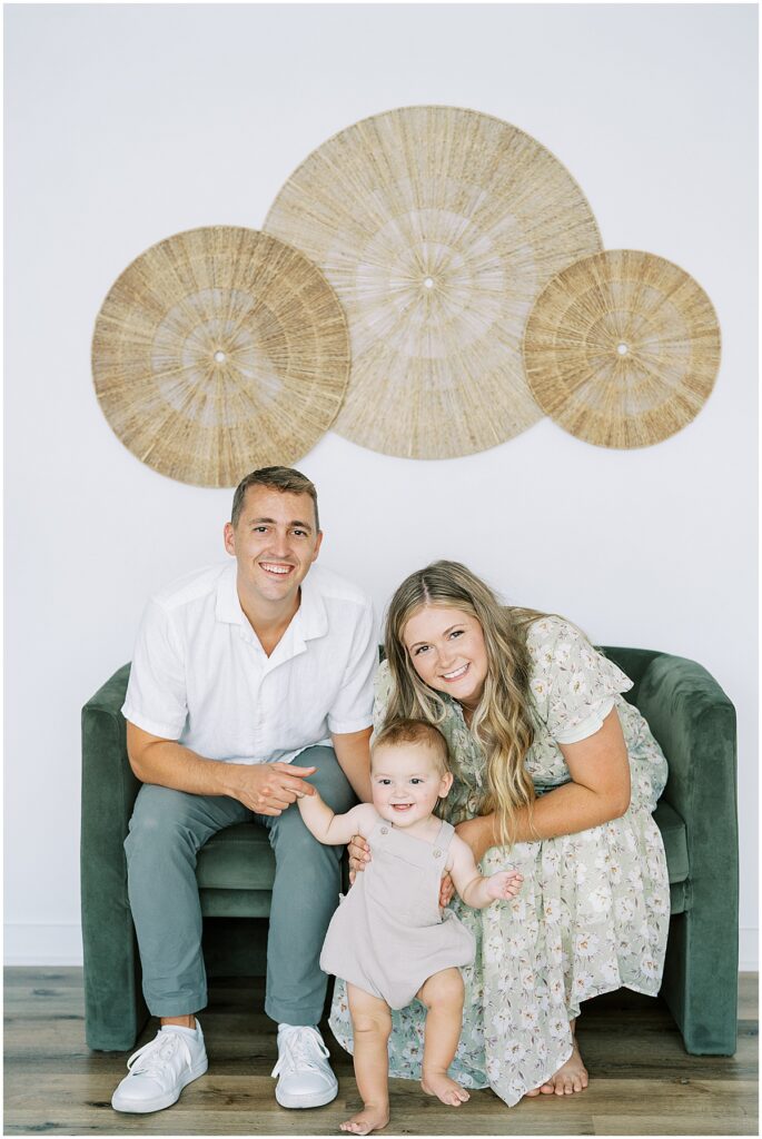 Family of three in green and white for studio photos in Indianapolis