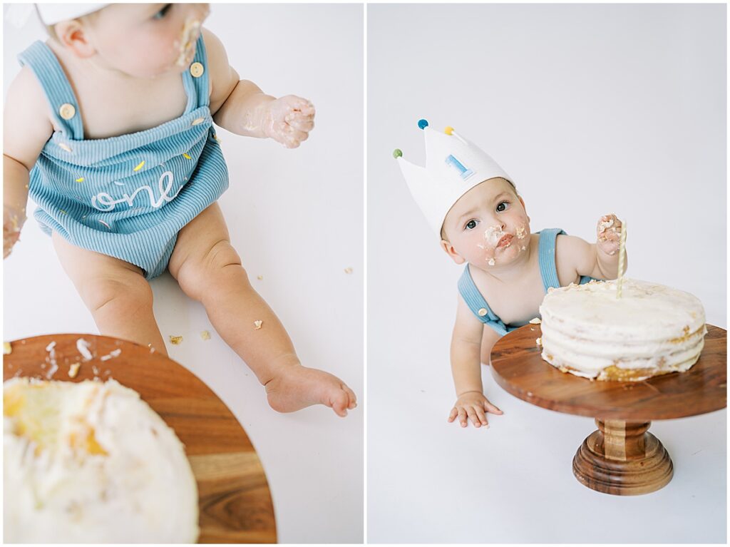 Baby in blue eats white cake during first birthday photos