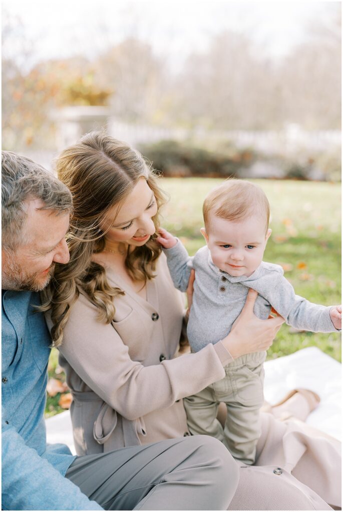 Family of three sit outside during fall mini session