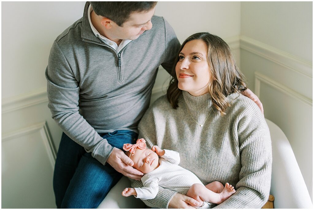 Mom looks up at dad while holding newborn during studio session