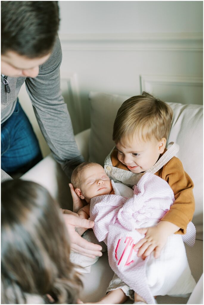 Newborn girl wrapped in monogrammed bow blanket during studio photos in Indianapolis