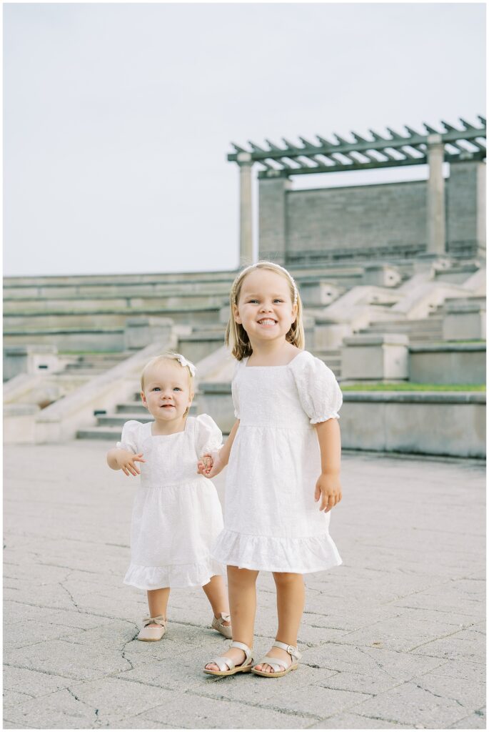 Matching young sisters in spring family photos at Coxhall Gardens in Carmel Indiana