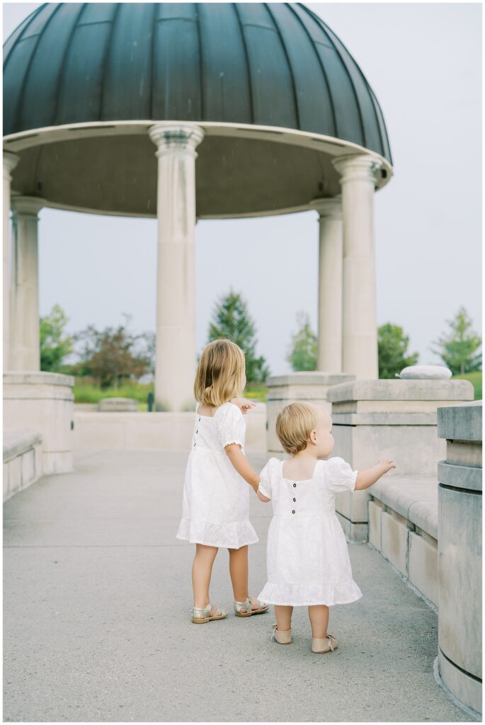 Sisters in white dresses enjoy family photos in Carmel