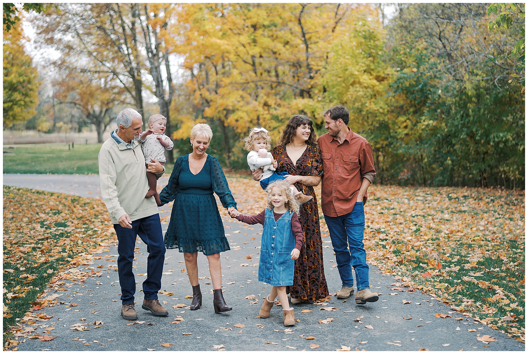 Family walk down path in fall during in home family photo session