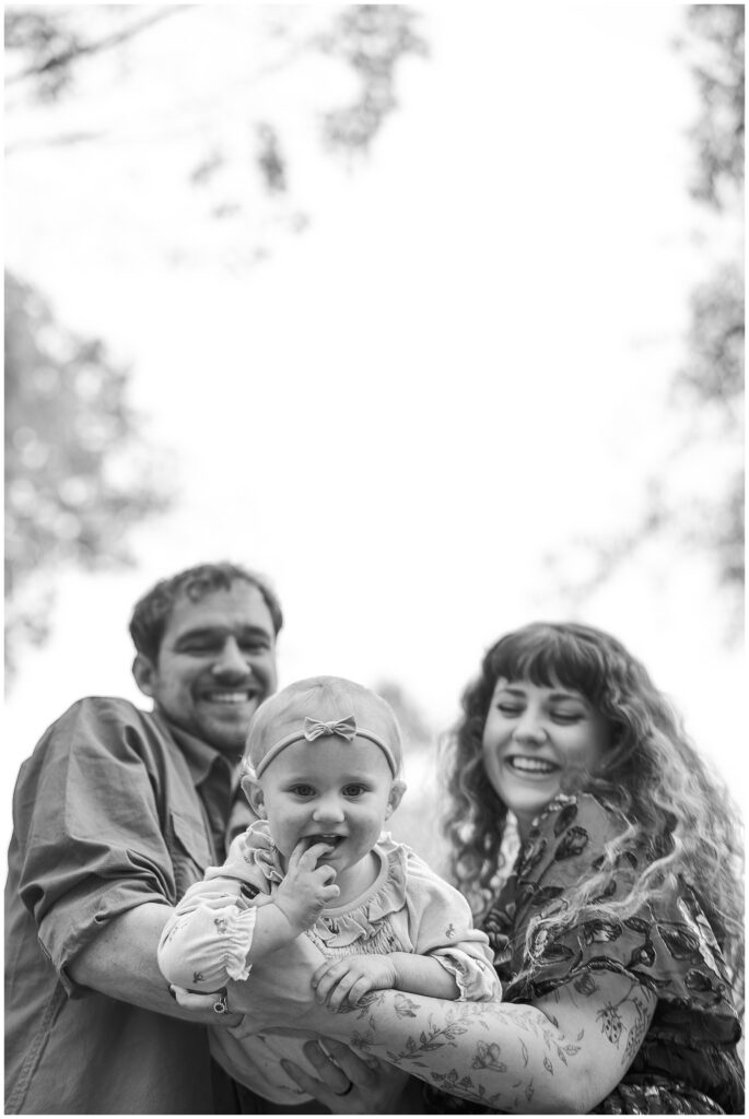 Parents play with daughter during lifestyle in home photo session