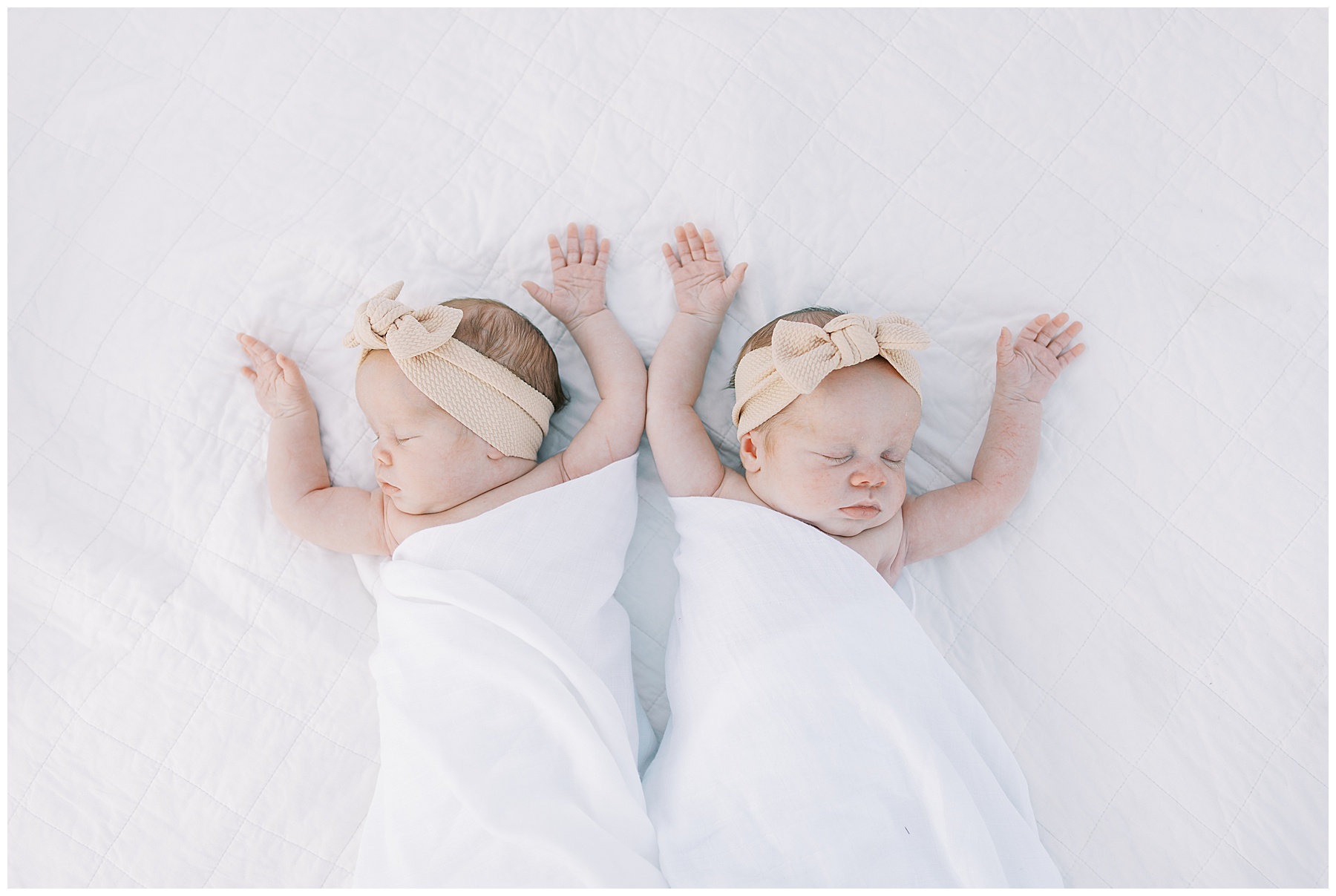 Twin newborn girls on blanket during family photo session in Carmel