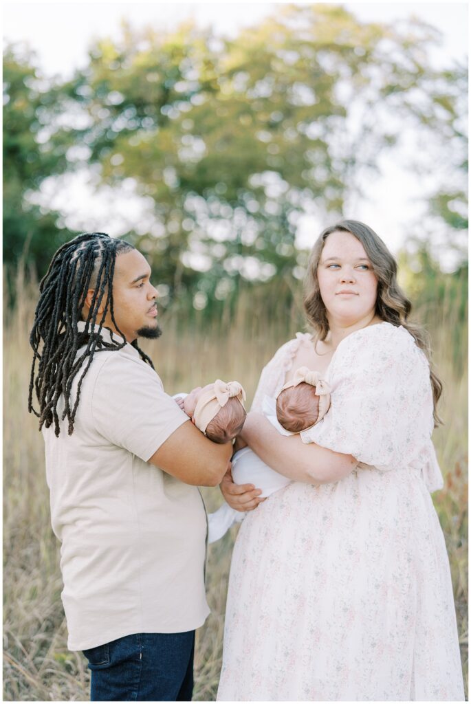 Parents each holding one of their newborn twins during family photo session