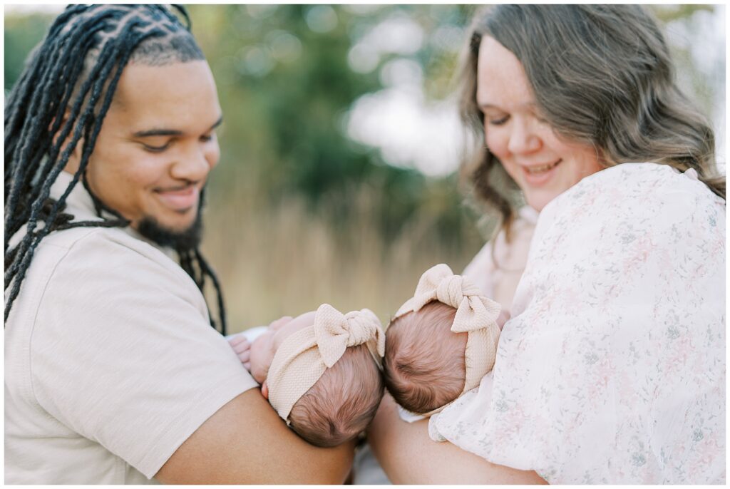 Parents each holding one of their newborn twins during family photo session