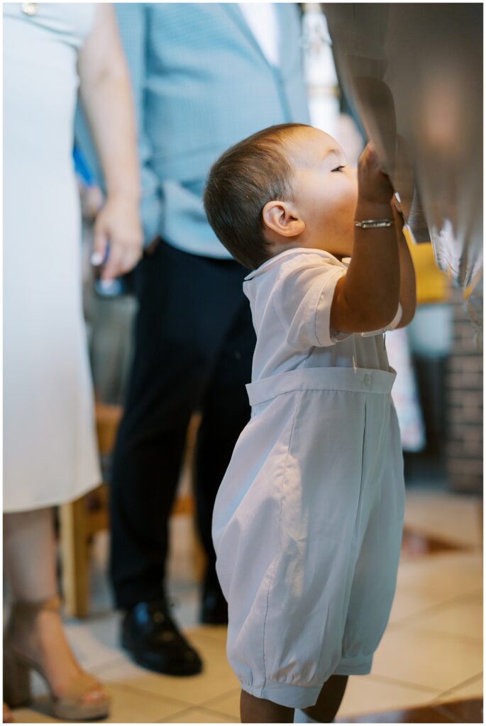 Child looking at water in baptismal font during Carmel Indiana baptism