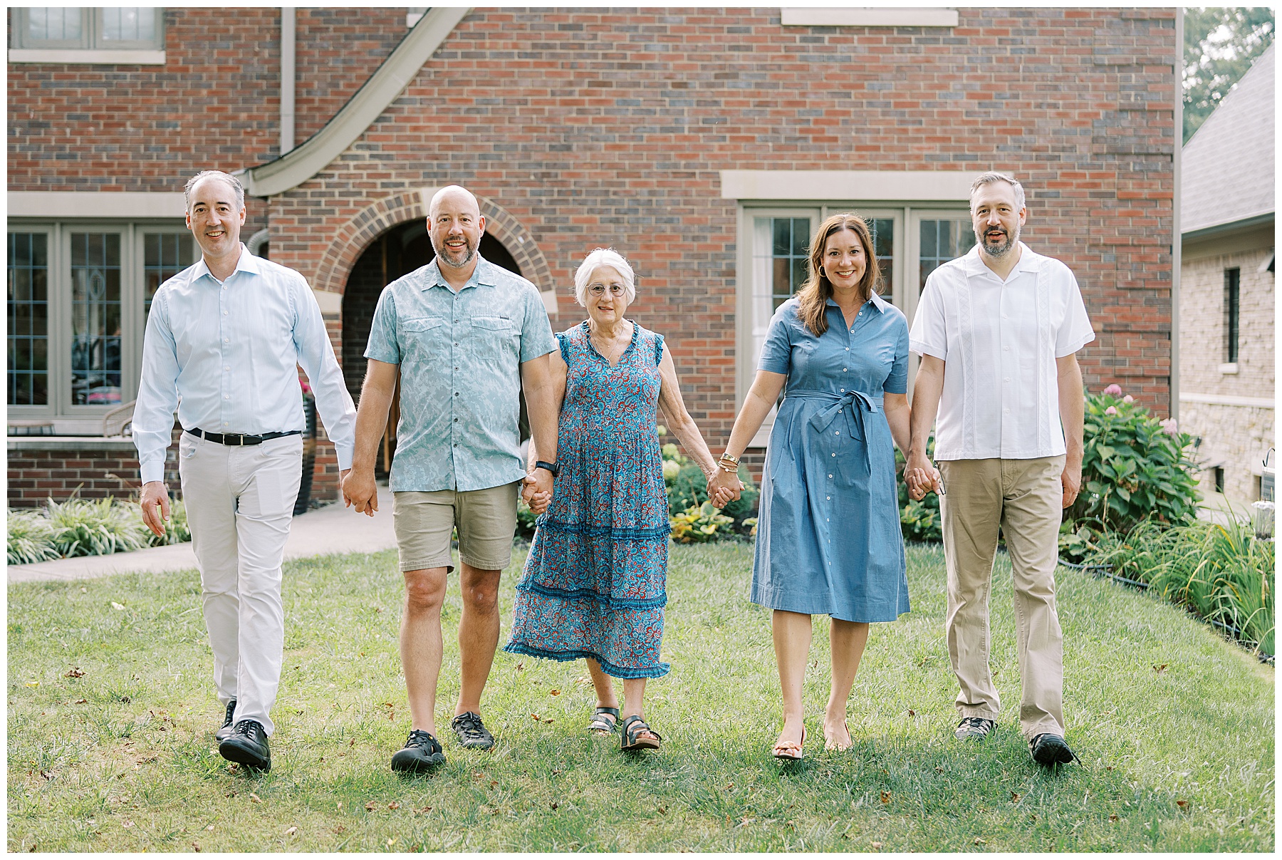 Multi generational extended family photo session outside of brick home