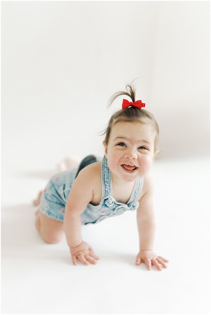 In studio first birthday photos of girl with red bow